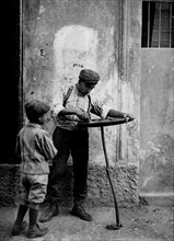 italie, milan, vendeur de rue vendant un gâteau aux châtaignes, 1910
