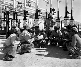 arabie saoudite, des ouvriers écoutent les instructions d'un technicien indien, 1952
