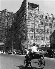 asia, india, calcutta, una via con impalcature e risciò, 1964