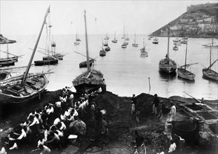 europa, italia, toscana, porto ercole, un gruppo di pescatori tira a terra una paranza, 1900 1910