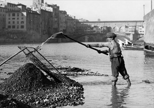 italia, toscana, firenze, renaiolo d'arno a lavoro presso il ponte vecchio, 1920 1930