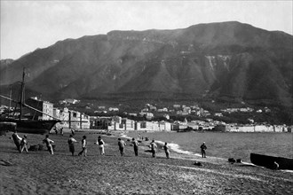 campania, castellamare di stabia, pescatori tirano le reti sulla spiaggia, sul fondo i monti lattari, 1910 1920