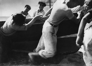 italia, campania, napoli, i pescatori tirano a secco i gozzi, 1940