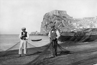 europa, italia, calabria, scilla, pescatori stendono le reti sulla spiaggia, 1920 1930