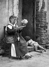 europa, italie, calabre, argusto, fileuse de laine avec enfant devant la maison, 1940