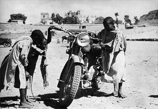 afrique, éthiopie, macallè, enfants intrigués par une moto, 1930