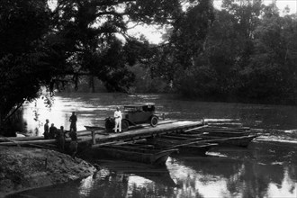 africa, congo belga, attraversamento del fiume tramite zattera che poggia su piroghe, 1927 1930