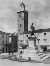 europa, italia, abruzzo, l'aquila, piazza palazzo, monumento a sallustio, torre del palazzo di giustizia, 1910 1920