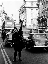 europa, inghilterra, londra, un portiere d'albergo chiama un taxi in piccadilly street, 1970