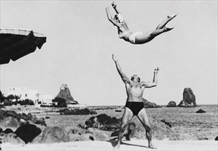 europe, italie, sicile, aci castello, paire de gymnastes au lido des cyclopes, années 1950