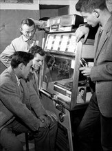 groupe de garçons devant un juke-box, 1968