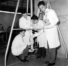 des techniciens nucléaires de l'ispra réparent un élément combustible, 1959