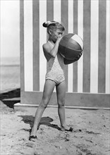 une petite fille jouant sur la plage, 1956