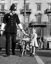 milan, un policier aide une petite fille à traverser, 1967