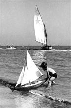 rimini, jouant avec un bateau sur la plage, 1956