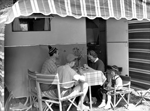 tourisme, camping, famille déjeunant sous une tente-caravane, 1950