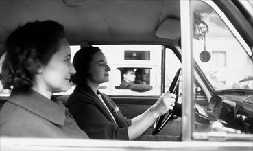 deux femmes dans une voiture arrêtée à un feu rouge, 1965