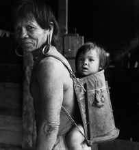 British Asia. Borneo. A Dayak With His Son On His Back. 1955