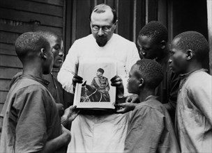 Africa. Kenya. A Missionary Shows The Photo Of The Leader To The Boys Of The School. 1920-30