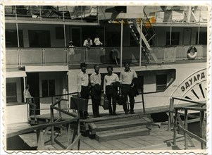 A group of four men in the background of a recreational ship.