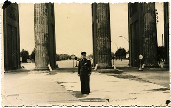 Captain of the Soviet Army in dress uniform standing between the columns of the Brandenburg Gate, Berlin.