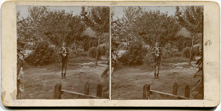 A stereo, a boy stands in the yard and holding a falcon.
