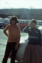 Two young Caucasian women posing near a Skoda car.