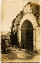 A woman stands near the entrance to the Grotto of Lermontov.