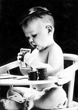 Child In High Chair With Playing Cards.