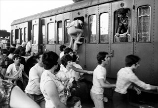 Passengers at the station during the summer exodus, italy 70s