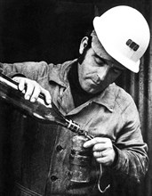 Miner loads the acetylene lamp, Iglesias, Sardinia, Italy 1970