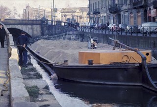 Italy, lombardia, milan, boat on naviglio canal carries sand