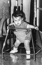 Little child with baby walker, 70's