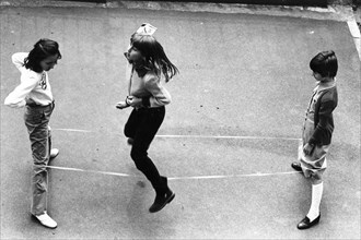 Children playing  elastic playground game, 70's