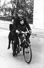 Grandfather and grandchilds riding bicycle, 70's