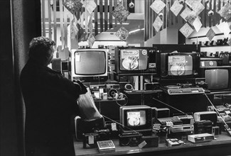 Woman in front of the windows of tv, trieste, 70's