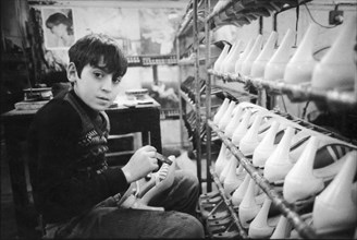 Little boy working in a shoes manufacturing, naples, italy, 70's