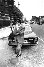 Driver attending near his car, london, uk, 70's