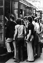 People at tram stop in rush hour, 70's