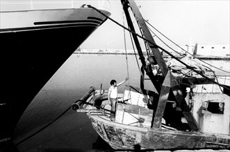 Fisherman on a fishing boat in mazara del vallo's harbour, 70's