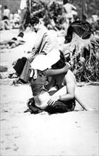 Couple in love kissing on the beach, 70's