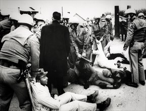 Troopers drag demonstrators to prison buses after about 60 persons laid down in the street to block a school bus from going to the all-negro social circle training school, georgia, 1968