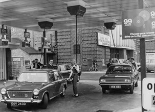 Service station with fuel pumps that descend from above, birmingham, england, uk, 1968