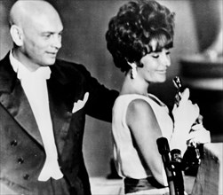 Elizabeth taylor, takes the oscar as best actress in the film BUtterfield 8, yul brynner behind her, santa monica, los angeles, california, april 18, 1961