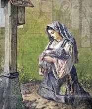 The prayer of the young mother for her baby in front of a cross