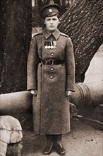 Tsarevich Alexei Nikolaevich of Russia in a Military uniform in front of a cannon