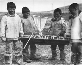Four Eskimo Boys With Toy Boat