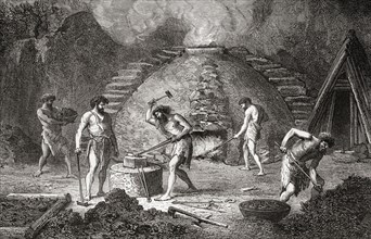 Men working at a primitive furnace used for the extraction of iron during the Iron Age.