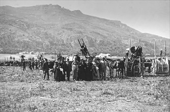 A large group of people standing with their horses and carriages.