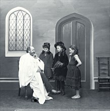 A vicar with three children in the church.